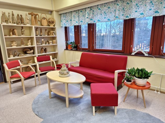 Kuvassa kirjastohuoneen oleskeluryhmä ja punaiset huonekalut
